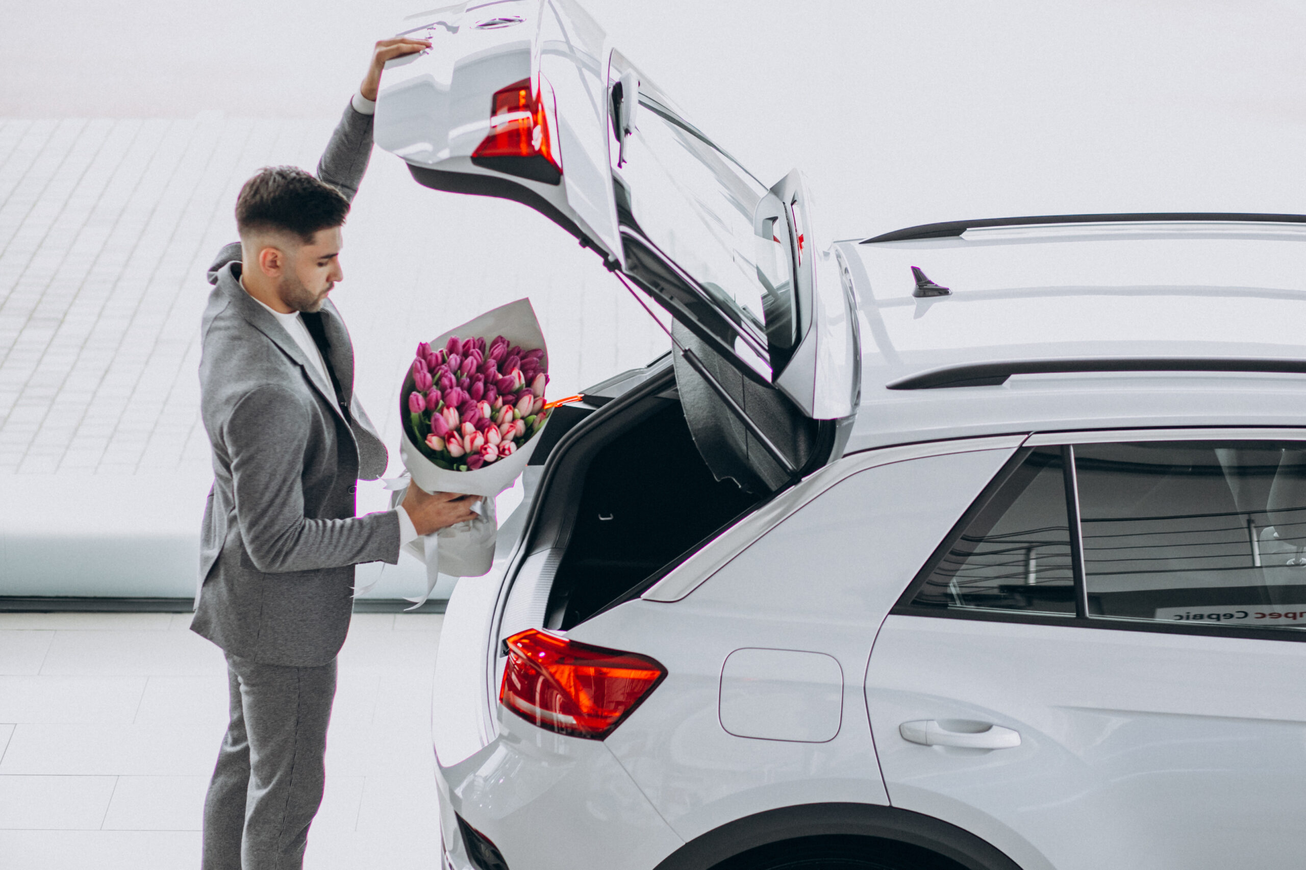 Young handsome business man delivering bouquet of beautiful flowers